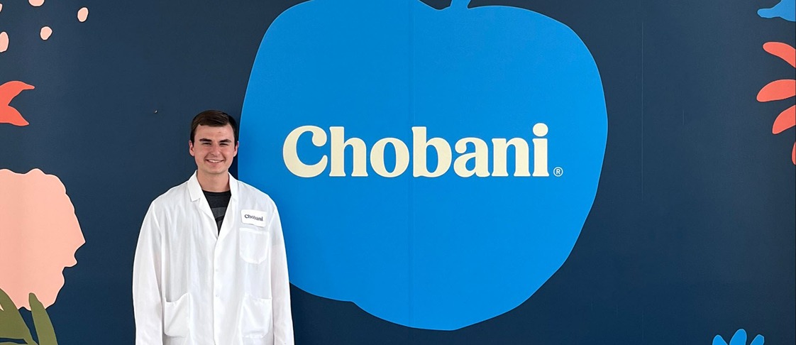 Jack Gross stands in front of the Chobani logo.