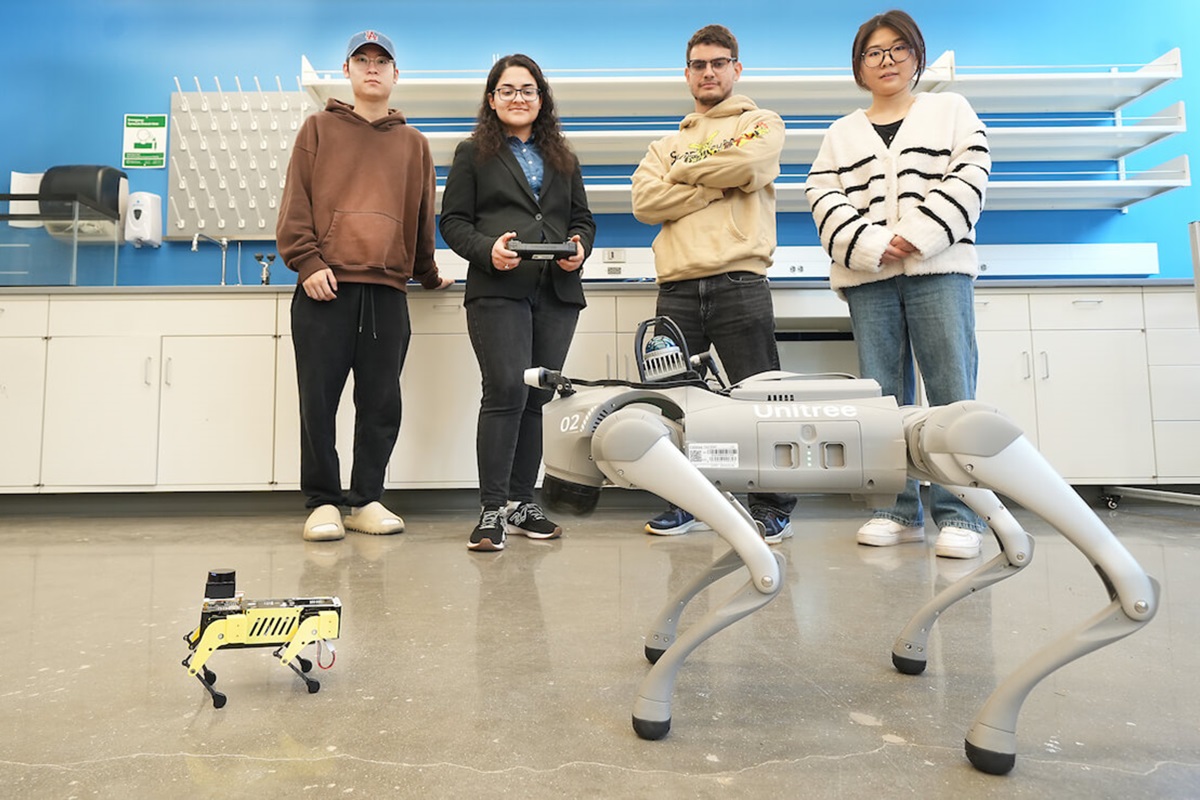 4 students standing with a robotic dog