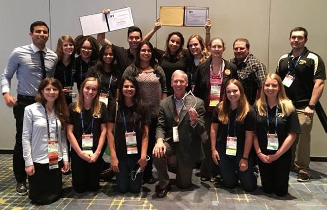 Image of group of students and professor posting showing their awards 