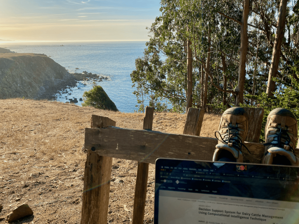 laptop open with a view of the coast