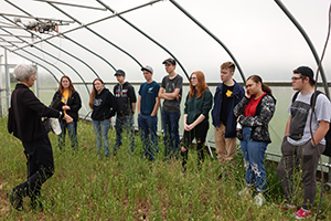 A scientist explains high tunnel food production to a group of students.