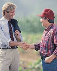 Agribusiness manager shaking hands with farmer