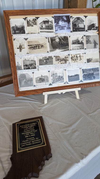 Hackman picture frame of history with the Purdue Farm Management Tour plaque the Hackmans were presented with at the Purdue Farm Management Tour.