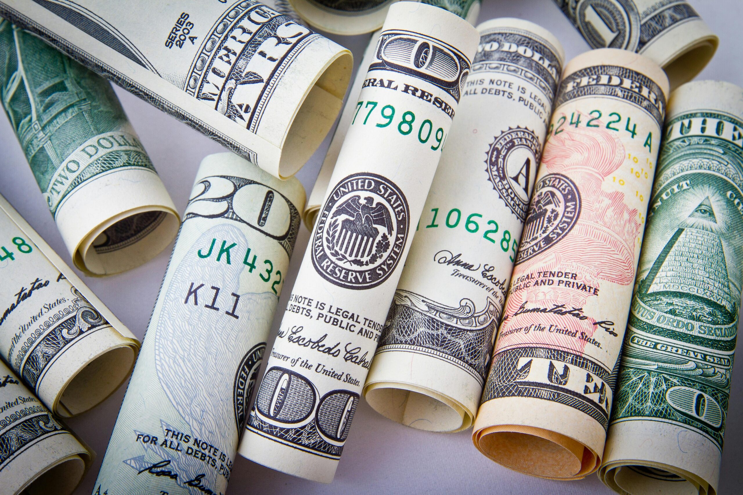 U.S. currency rolled up laying side-by-side