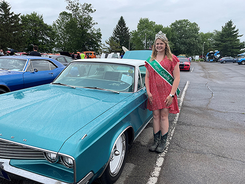 kassidy standing by classic car
