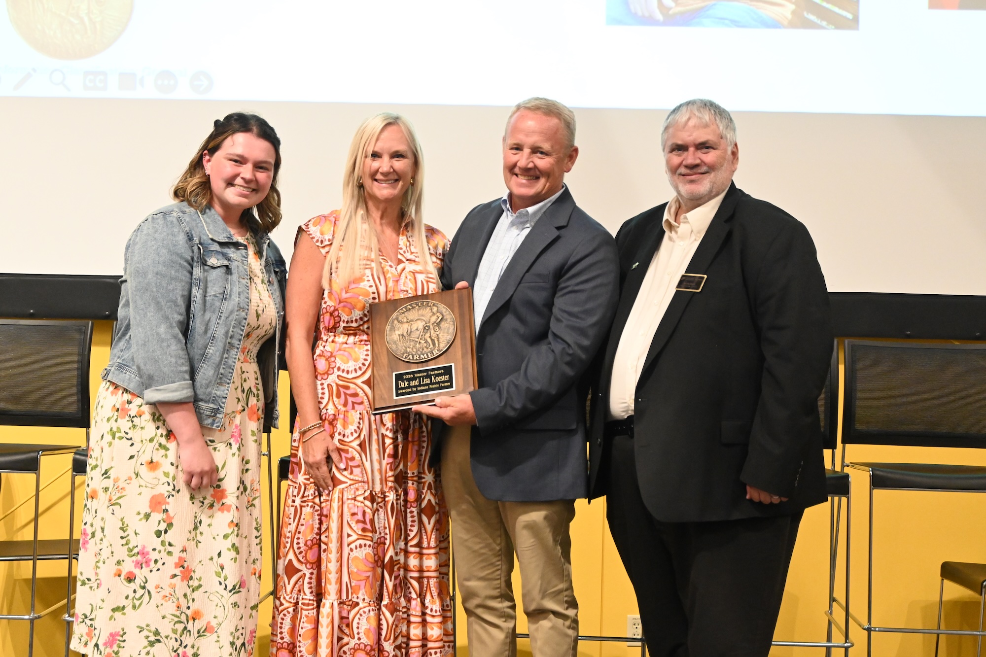 Allison Lynch and Dean Engel standing with Dale and Lisa Koester holding their Master Farmer award