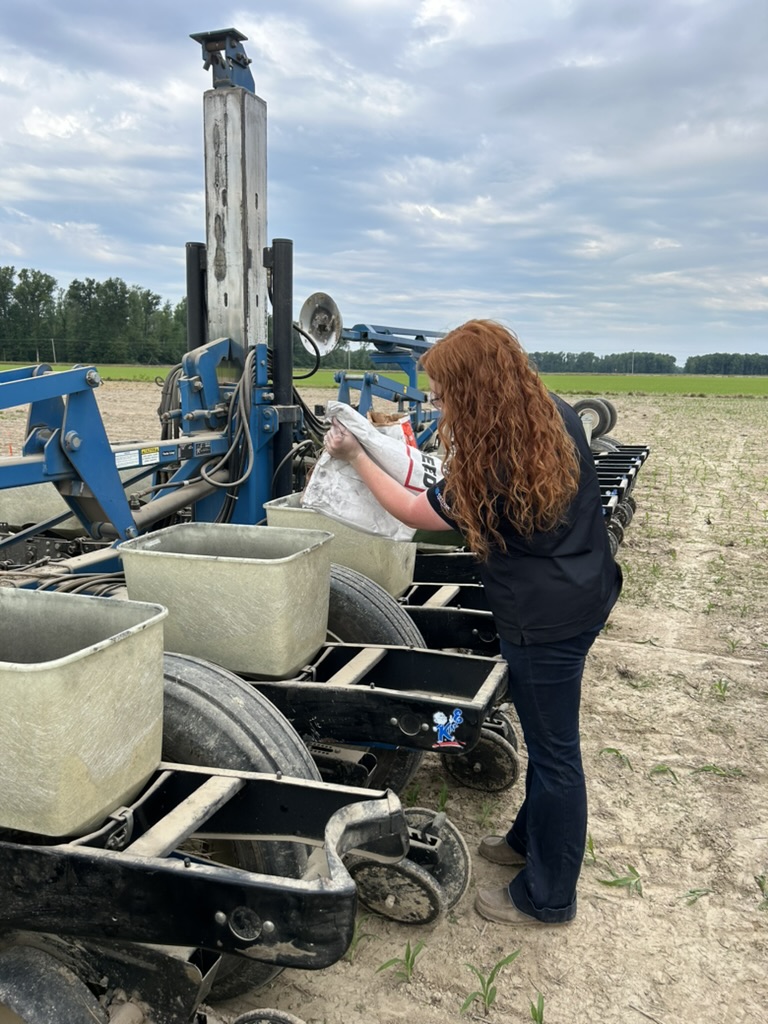 Madisyn planting seed in a field