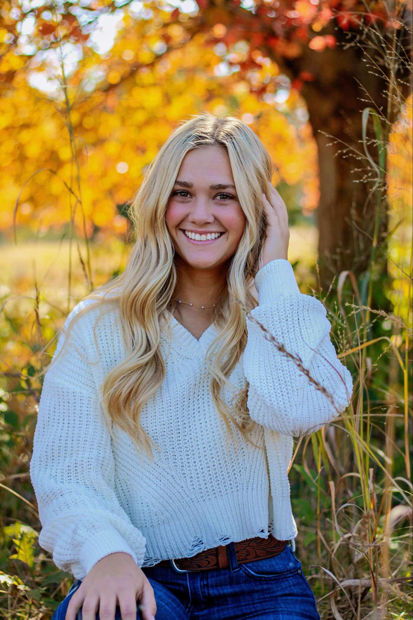 Madison Haynes posing in front of fall trees