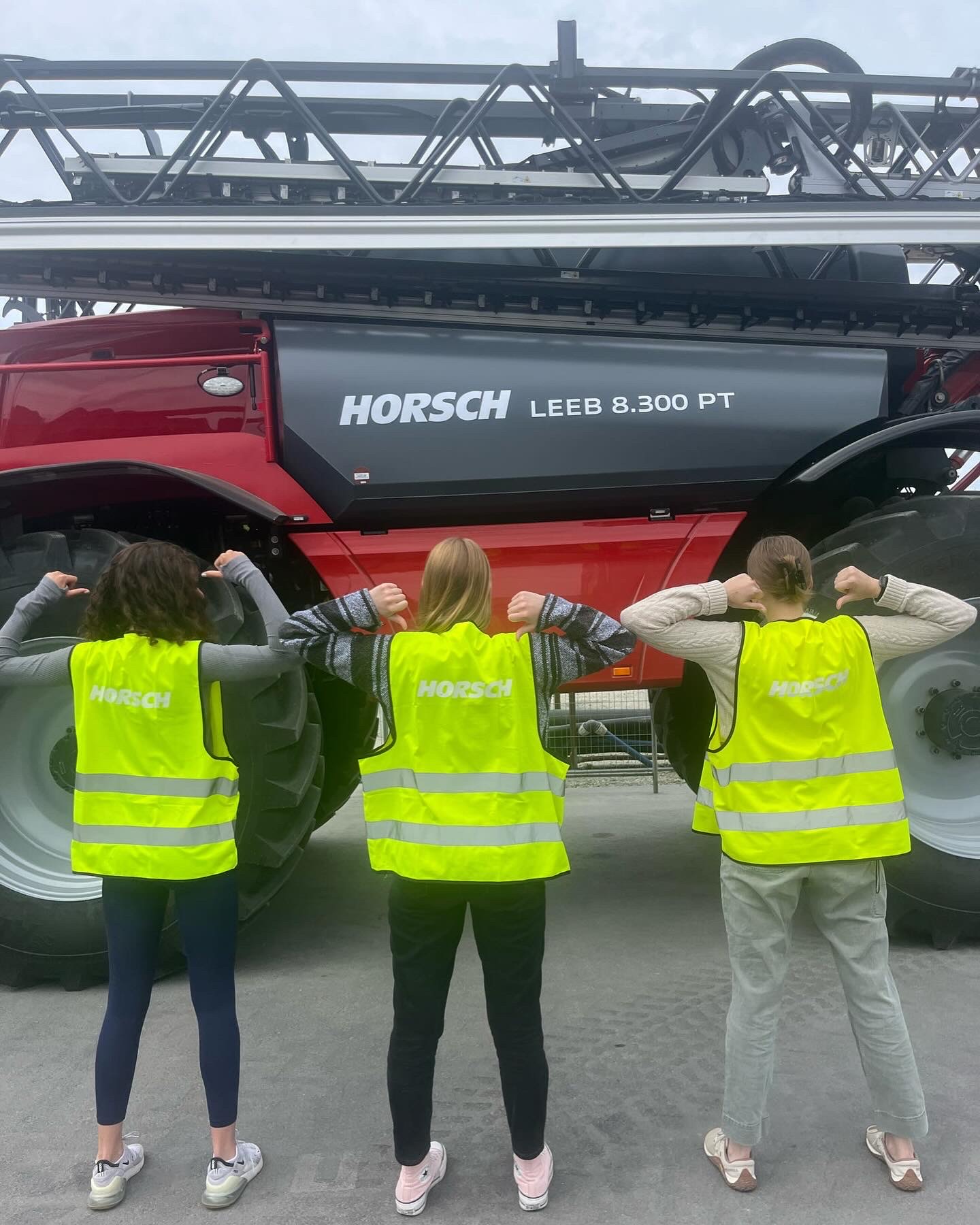 Baker with friends wearing safety vests in front of a Horsch machine