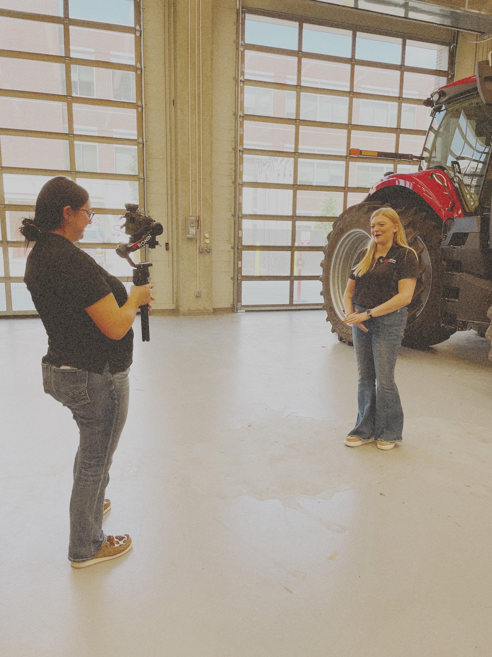 Blacker filming a student in front of a tractor