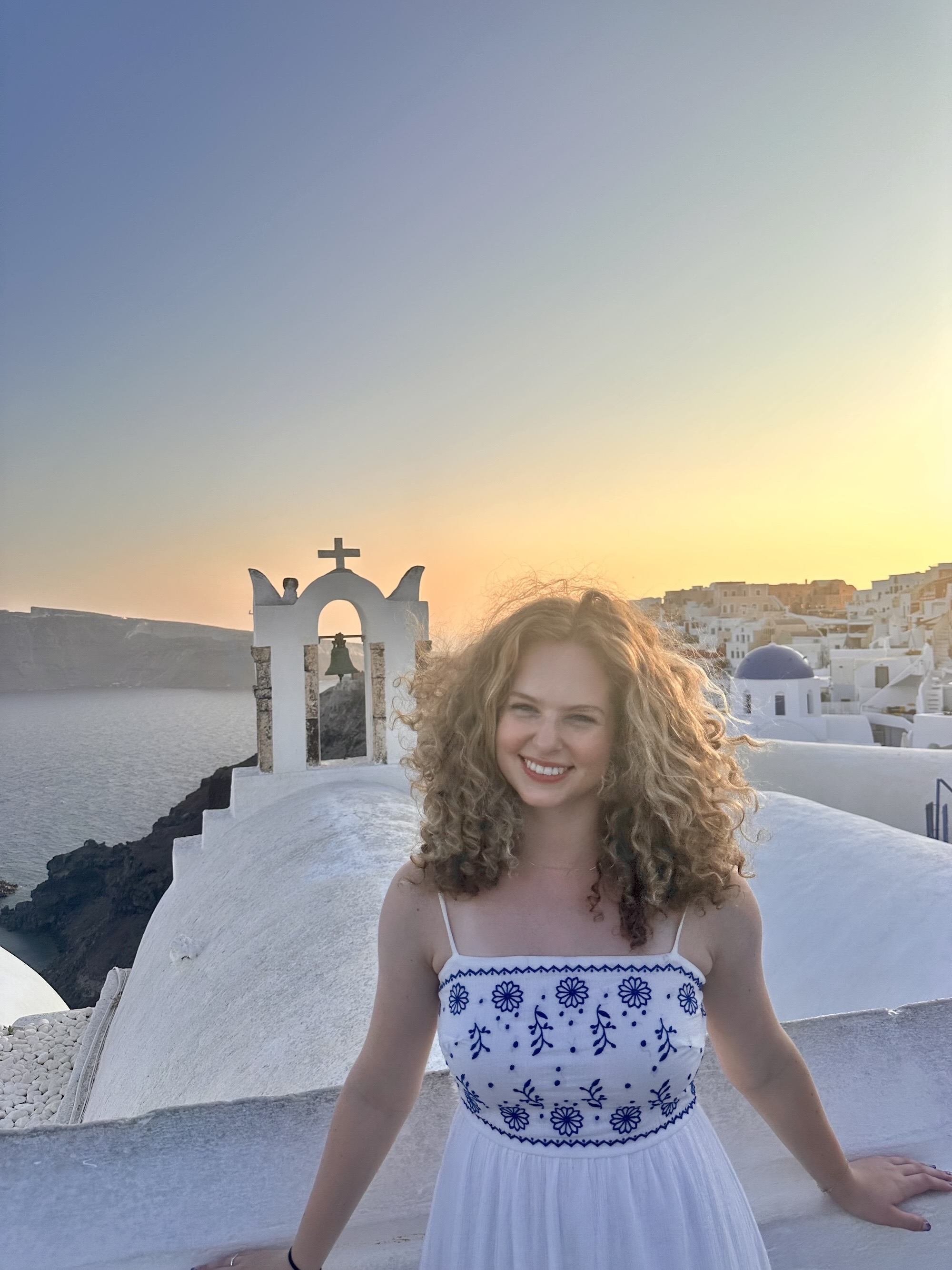 Clary standing on top of a building with Greek architecture in the background