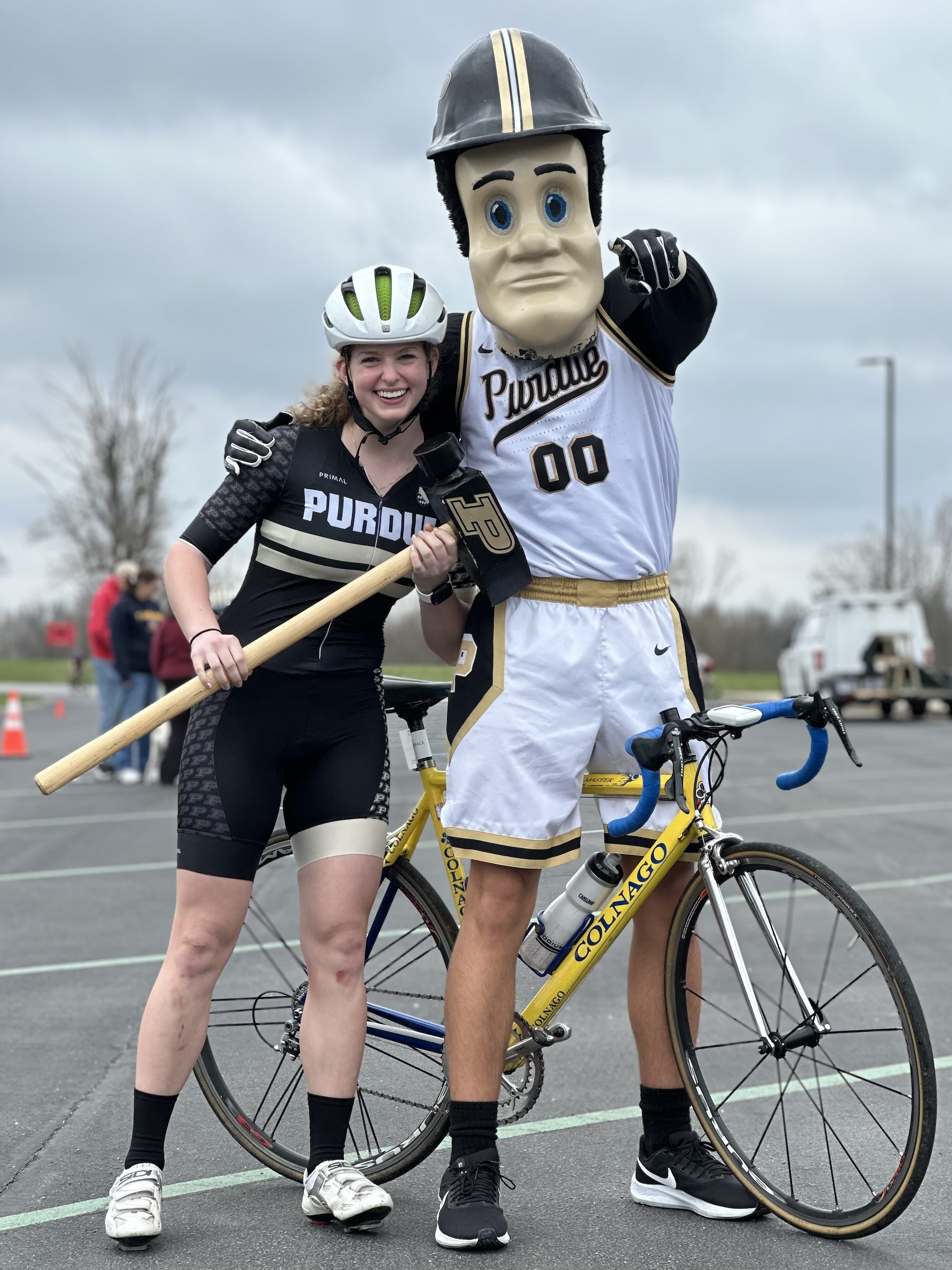 Clary holding Pete's hammer and standing next to Pete on a bicycle