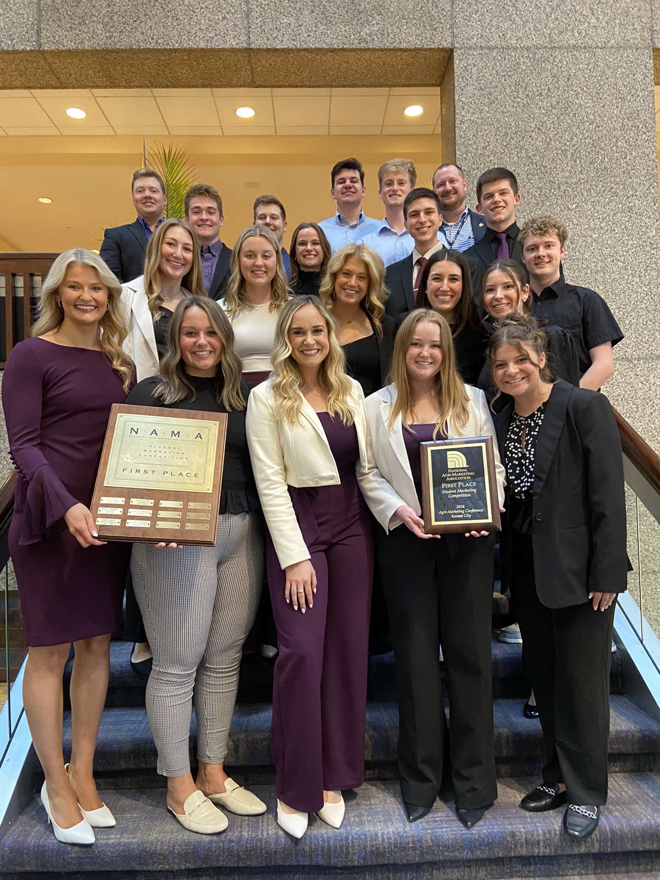 Kelsay standing with NAMA team holding 1st place plaque