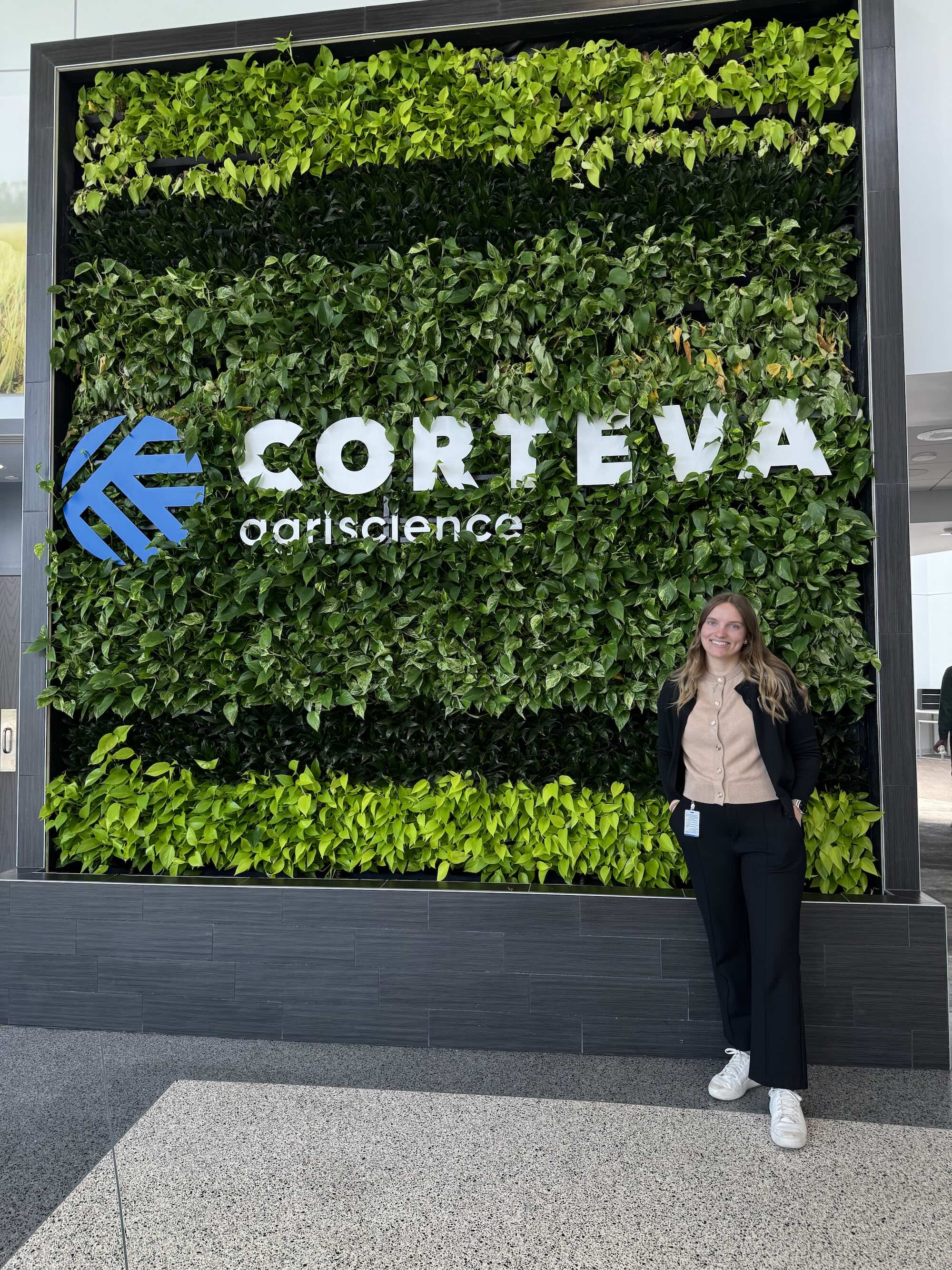 Koenig in front of Corteva Agriscience sign in a leaf wall