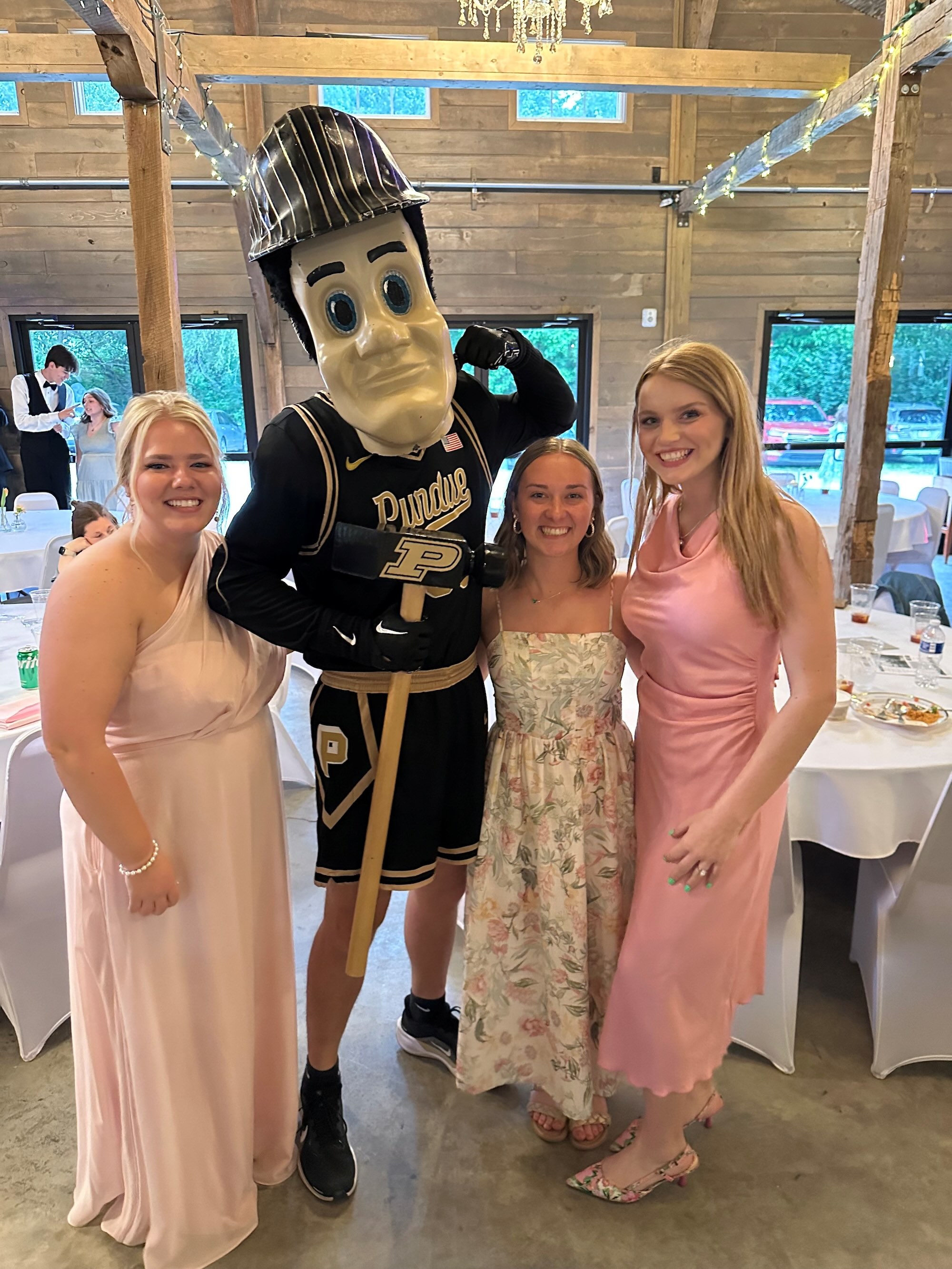 Logue in formal wear with friends posing with Purdue Pete