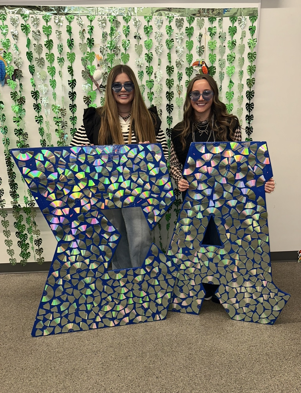 Markley with friend behind glittery Sigma Alpha letters