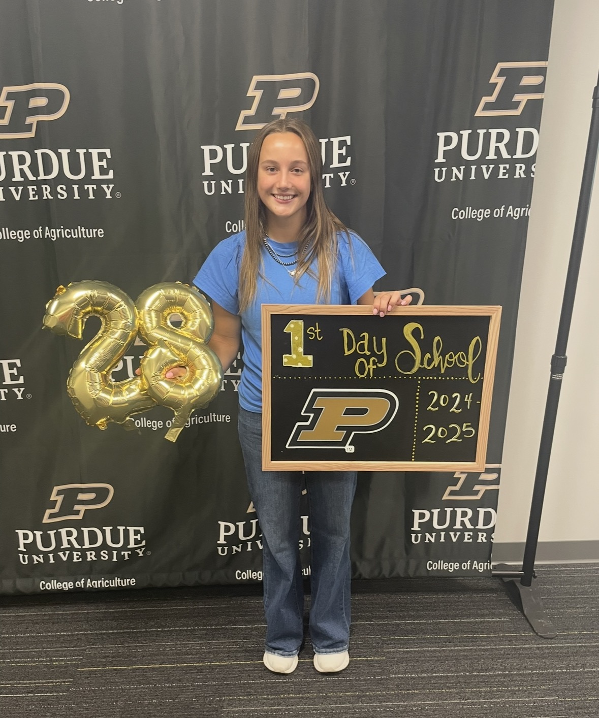 Markley holding a 1st day of school sign