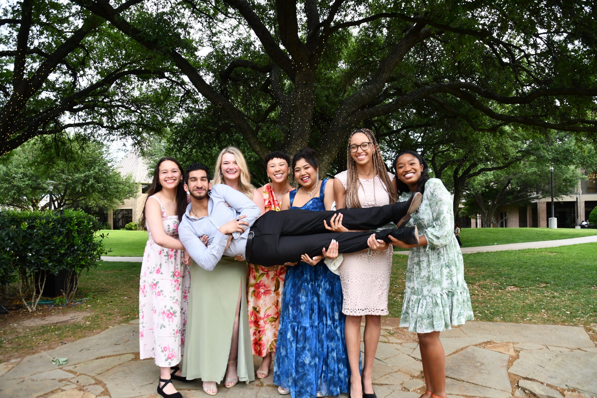 Piliang with friends holding a person horizontally