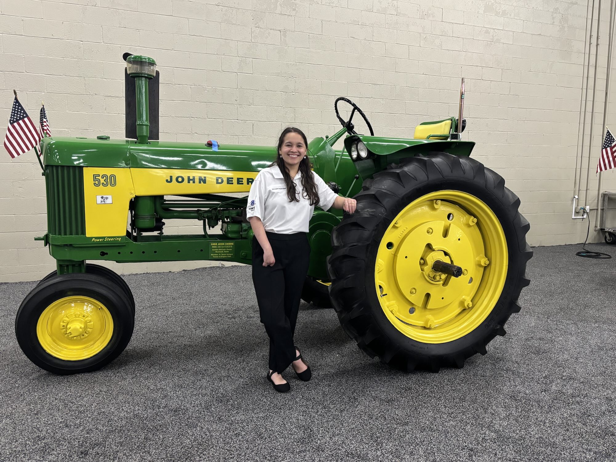 Piliang standing in front of John Deere tractor
