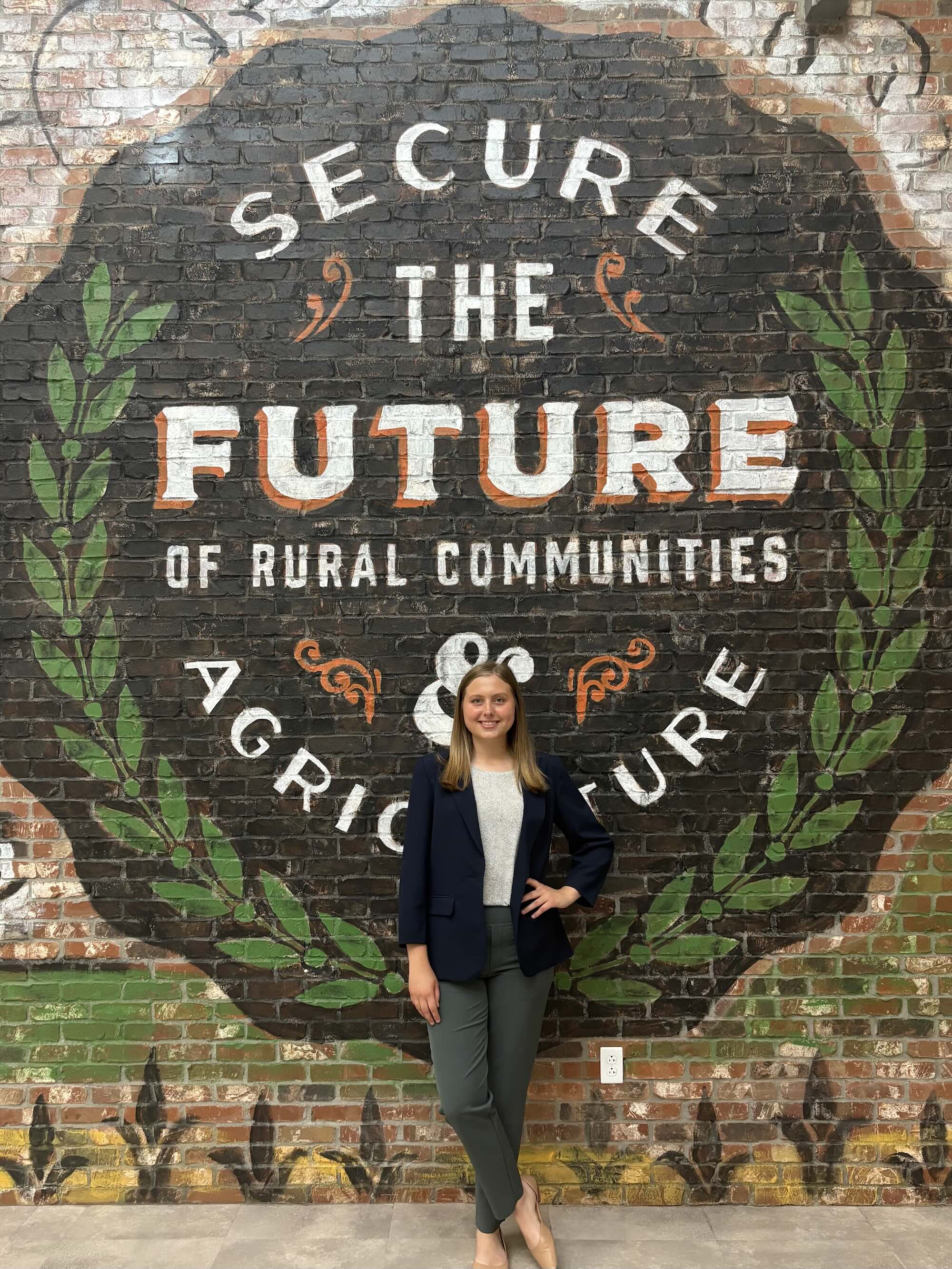 Recker standing in front of brick wall with ag phrase