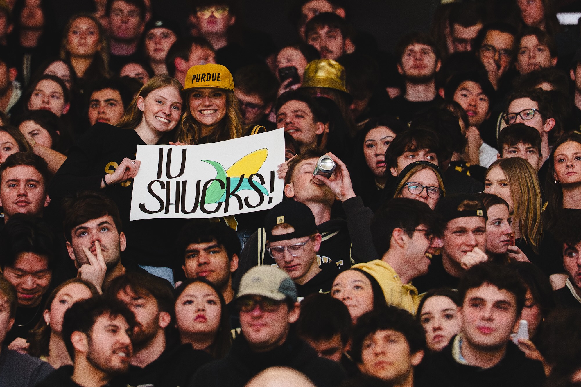 Roberts with friend holding IU Shucks sign in sports audience