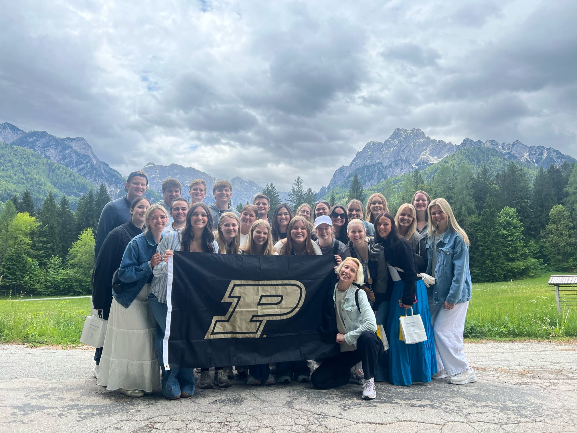 Group with the Purdue flag by the mountains