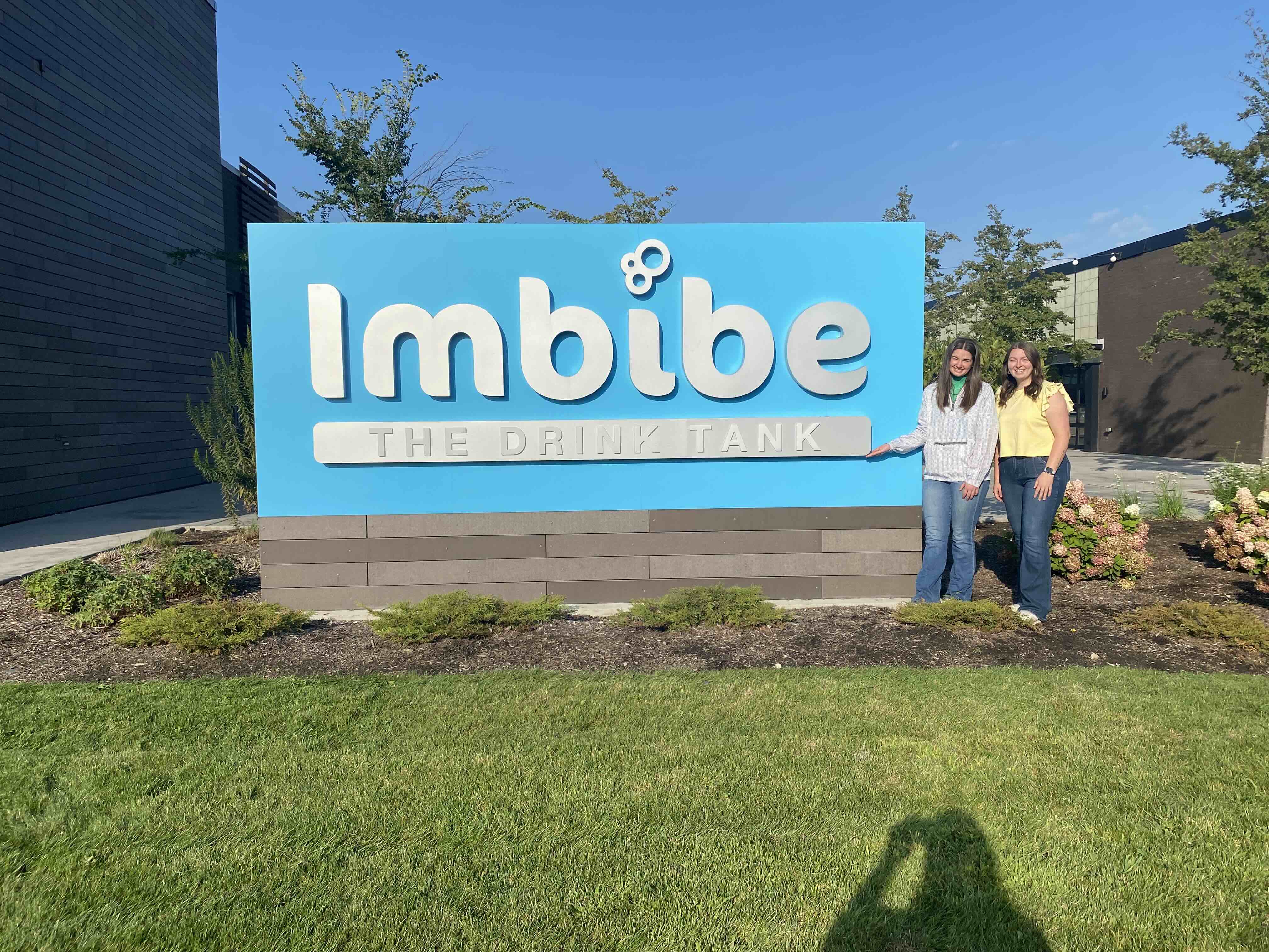 Laci and Kylie in front of the Imbibe sign