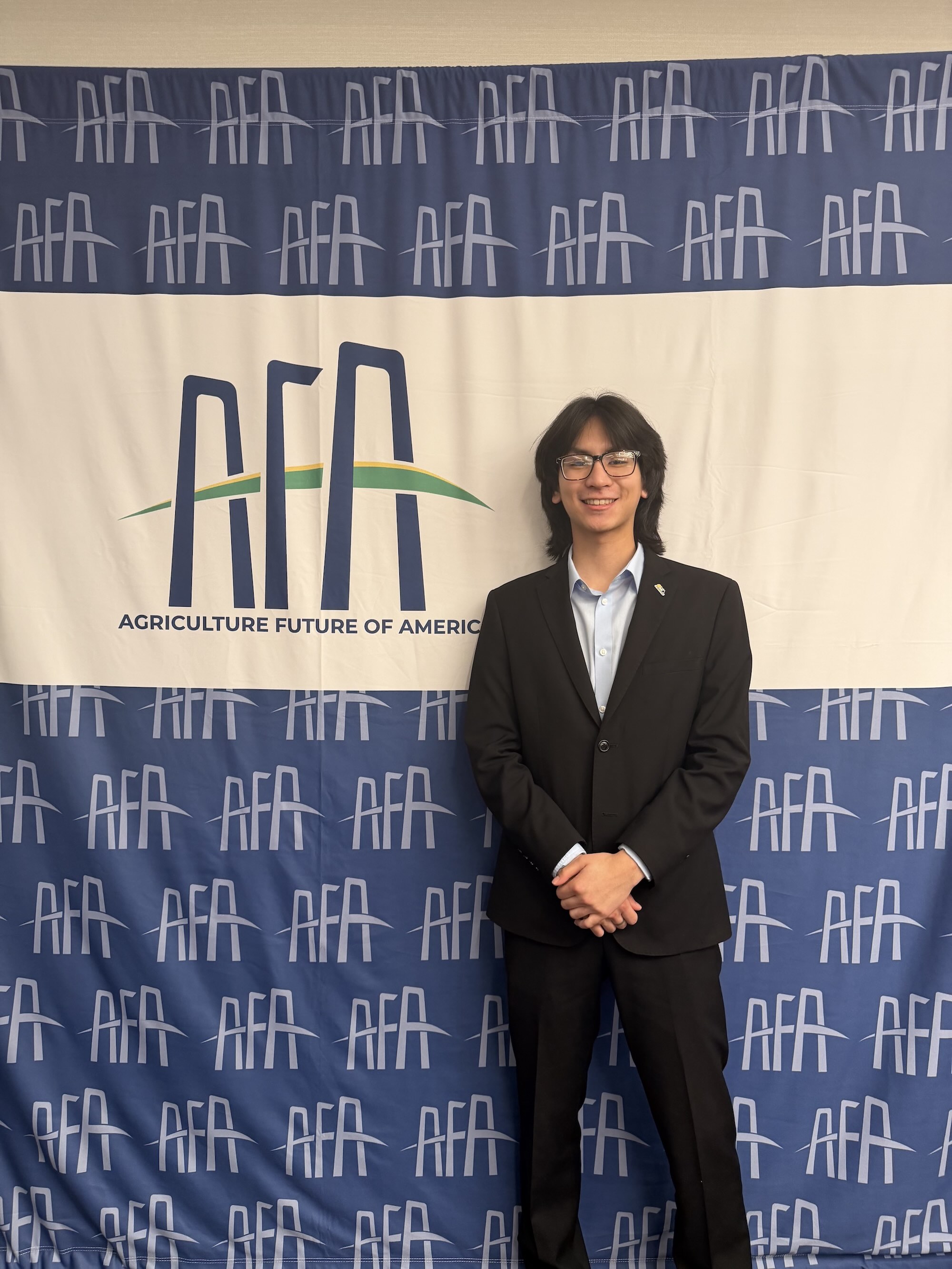Kenny Yamauchi standing in front of AFA banner