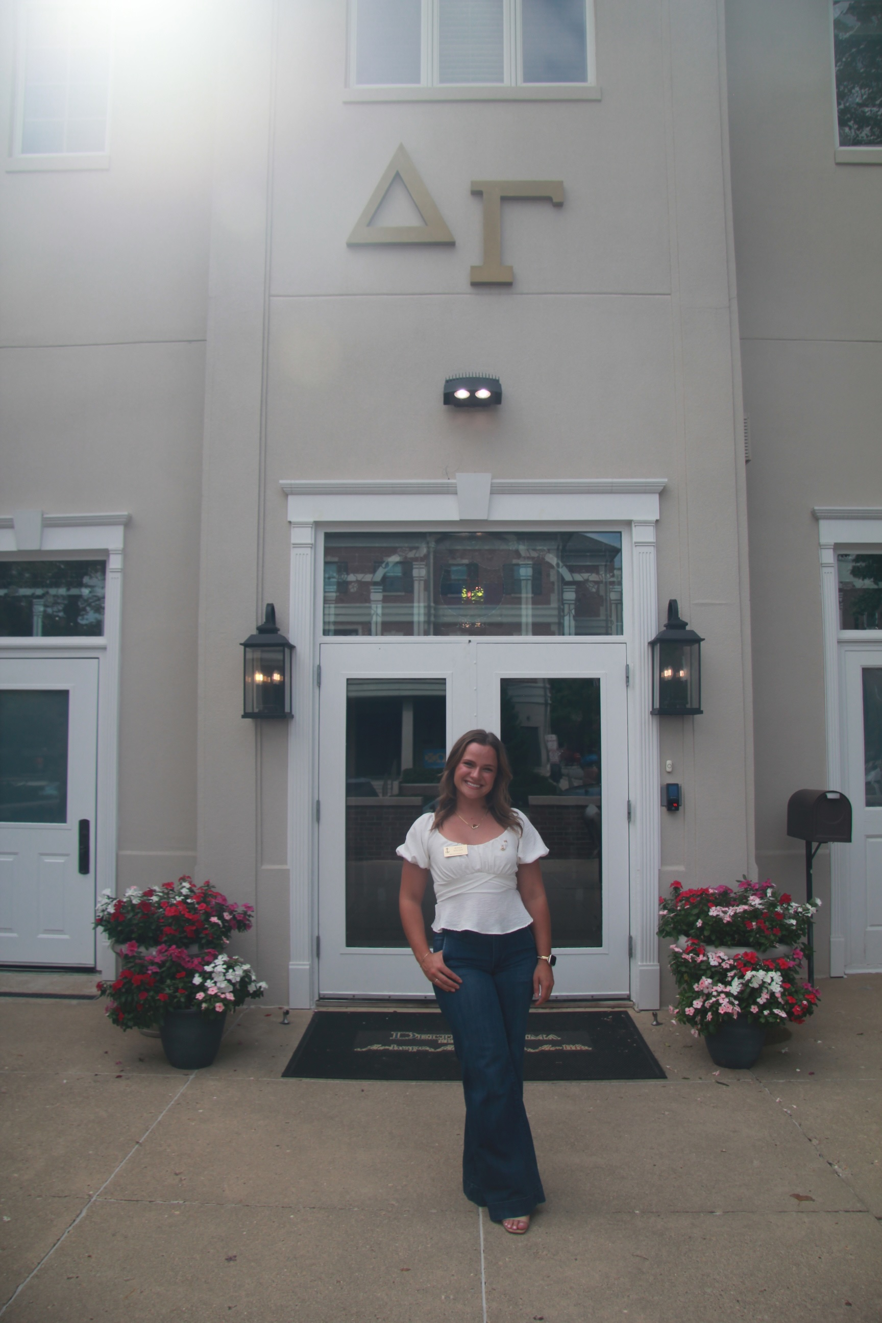 Jenna Kelsay standing in front of Delta Gamma house