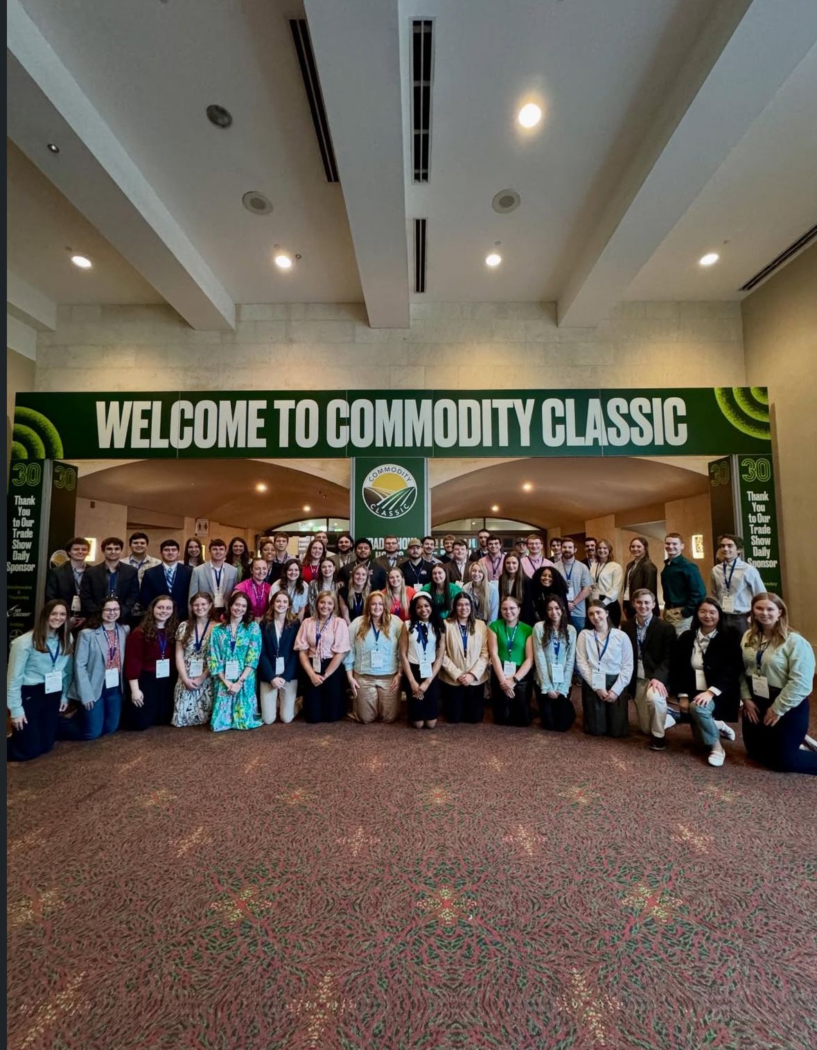 AFA technology group photo in front of the commodity classic welcome arch