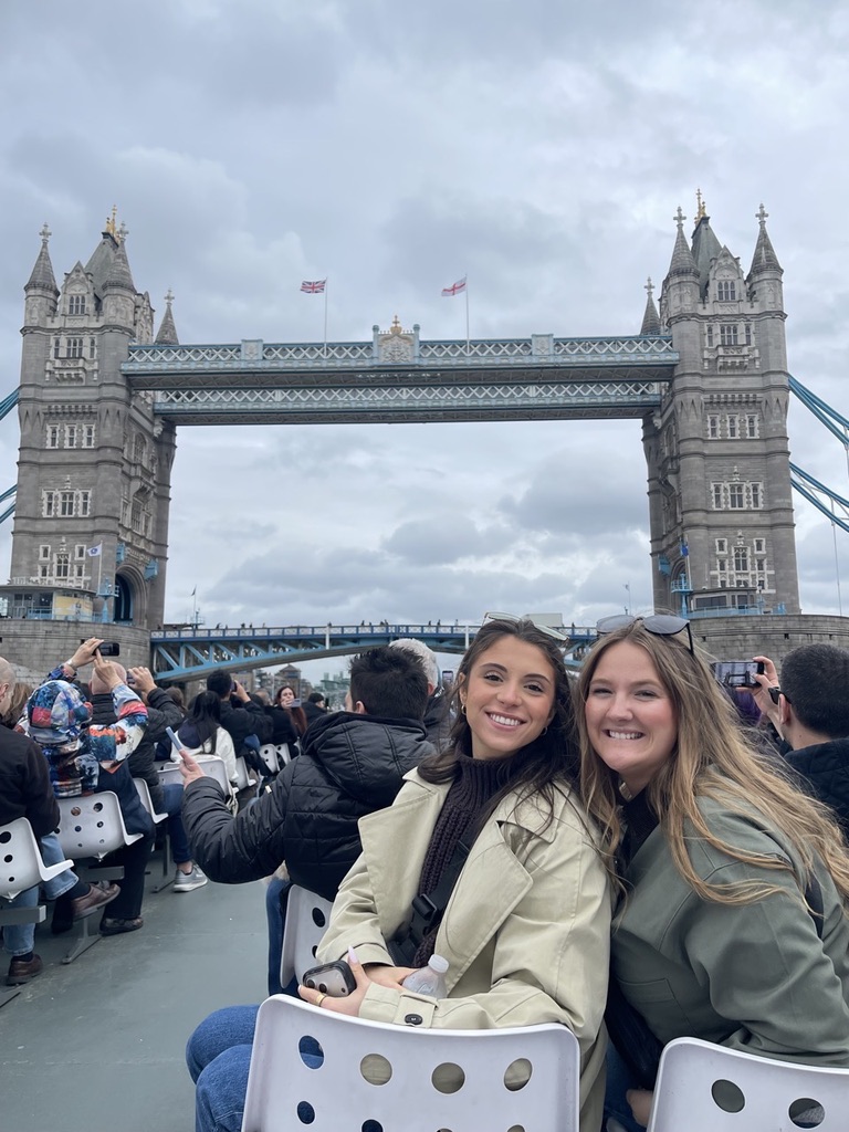 Klinkhamer and a friend on a sightseeing boat with Tower Bridge behind them; other passengers are photographing the bridge.