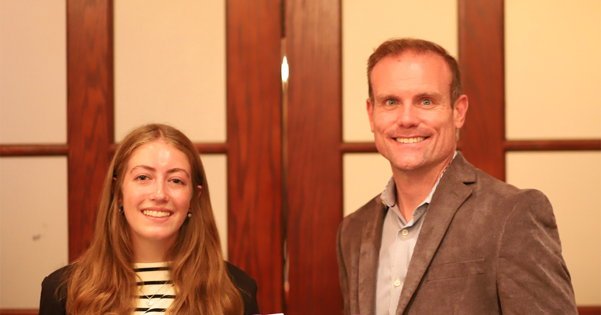 Emma standing with Purdue alum