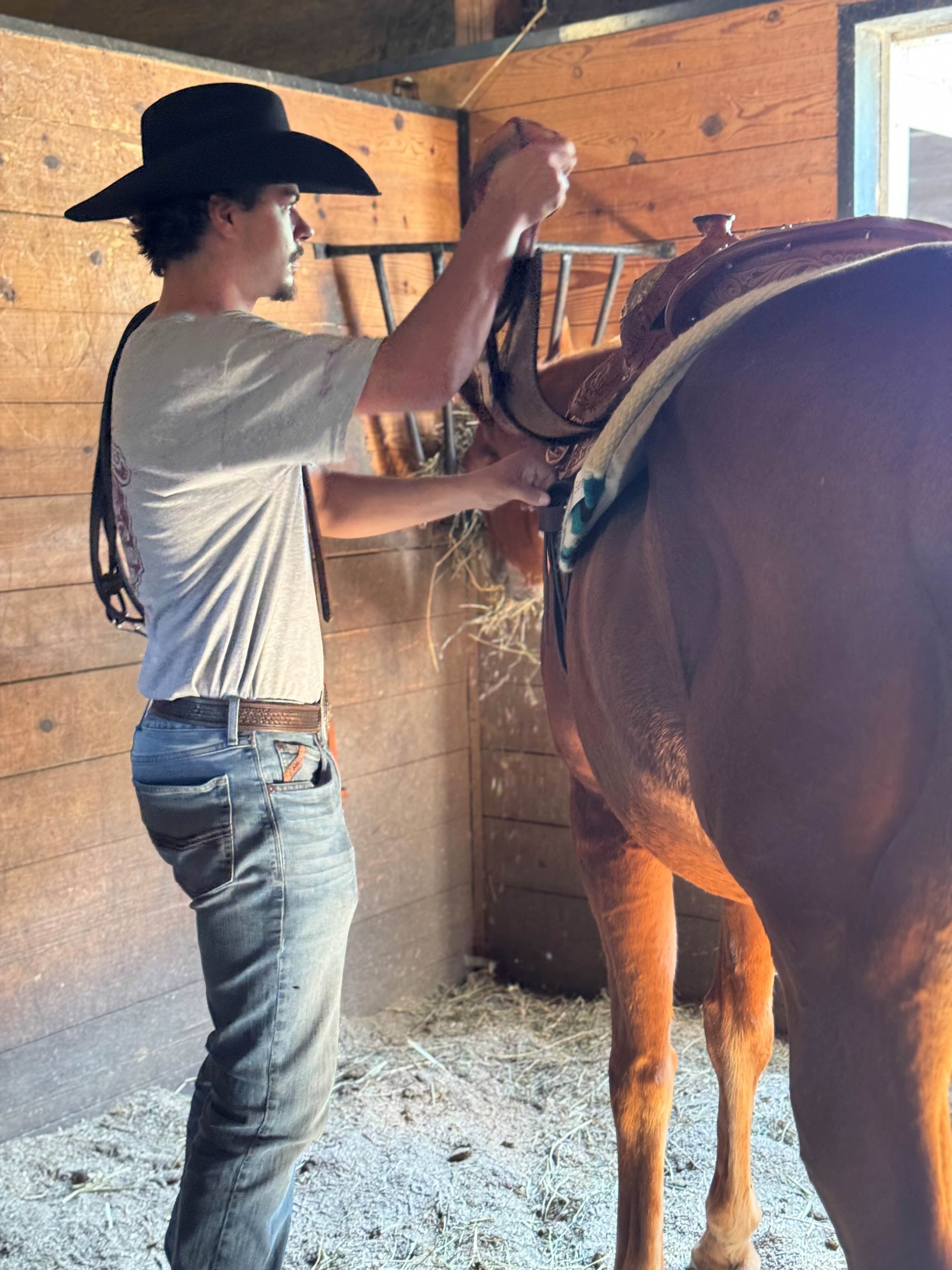 Braden saddling up a horse