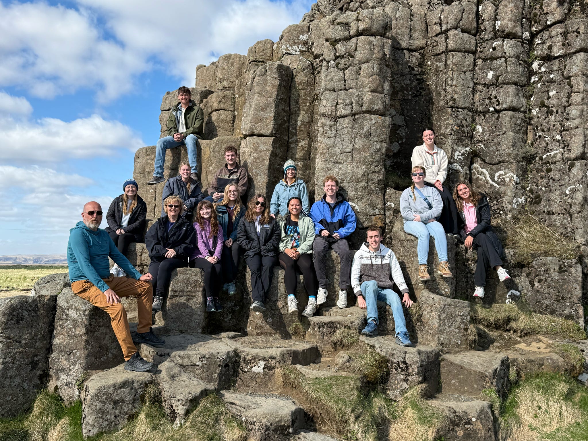 Iceland study abroad group in front of a wall of rocks