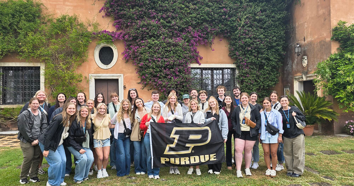 Study abroad group posing in front of a large house in Italy