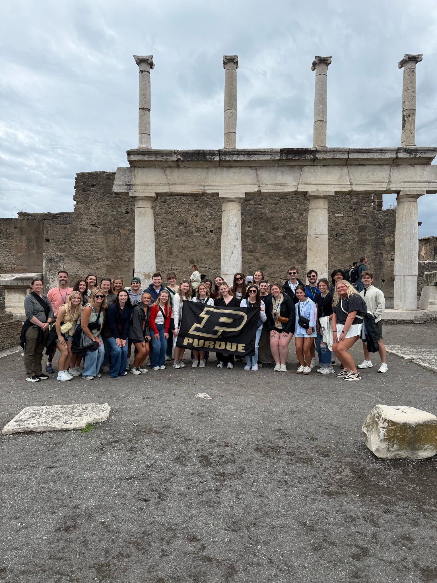 Study abroad group in front of Italian city ruins
