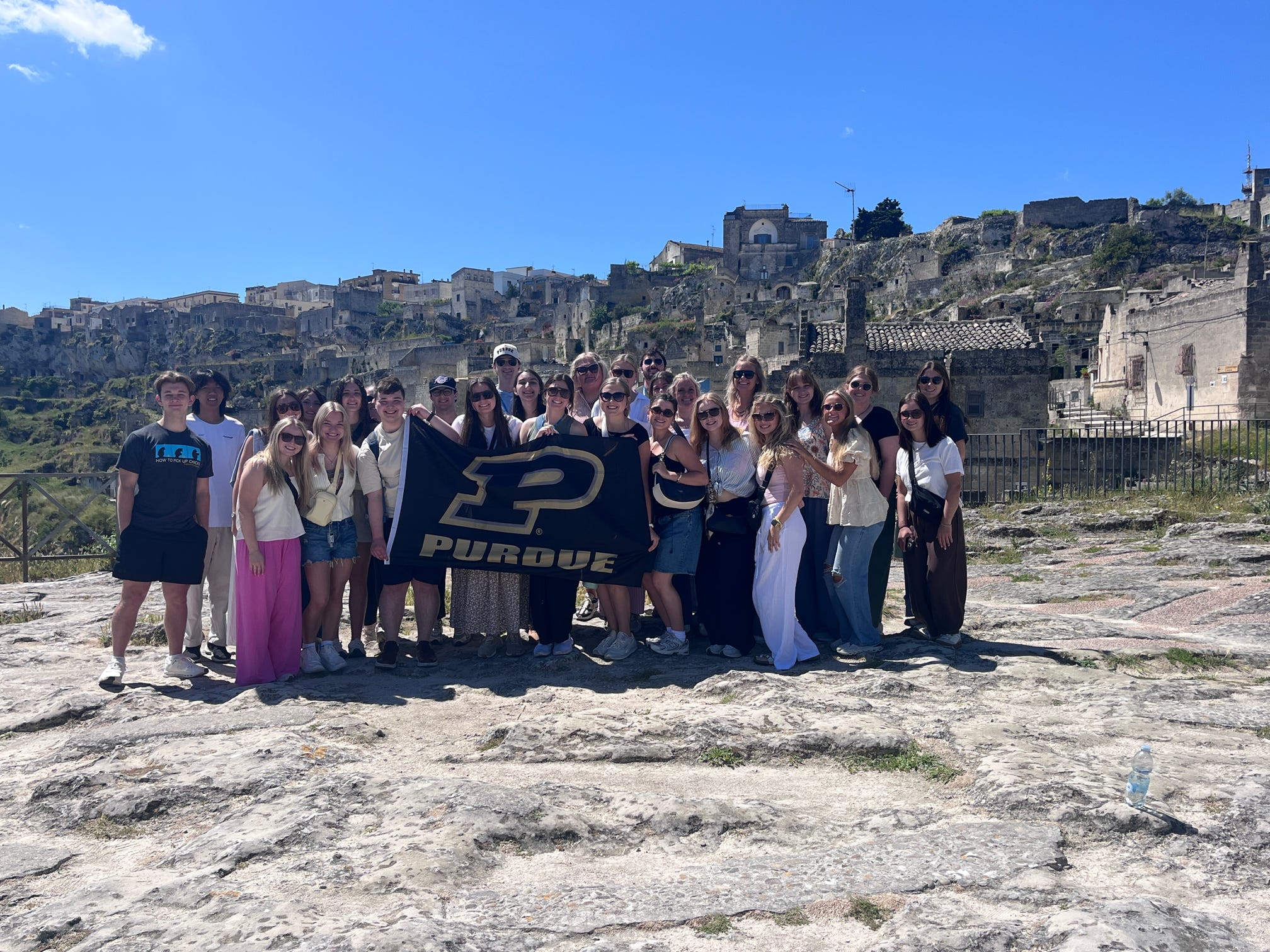 Study abroad group standing in front of seaside Italian city