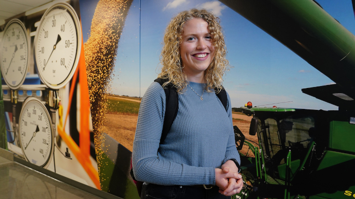 A woman with agriculture equipment in the background