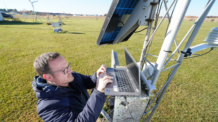 climatology staff member working on a weather station