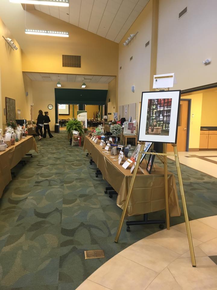 The lobby is being used for a silent auction with various rows of tables set up with gift baskets. Easels are available for any posters or signage.