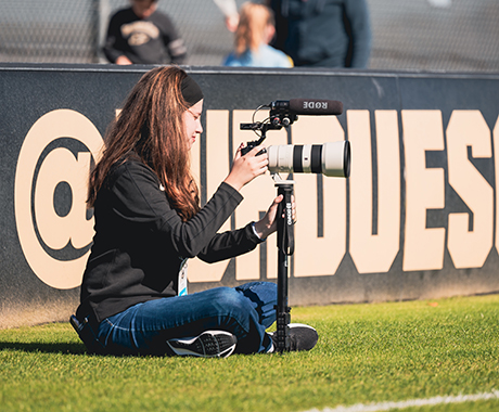 Student shooting photos at a sporting event