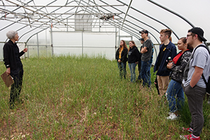 A scientist explains high tunnels to a group of students.