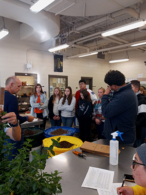 A scientist explains suitable soils for hydroponics to students