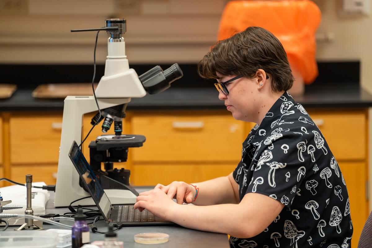 student looking at microscope