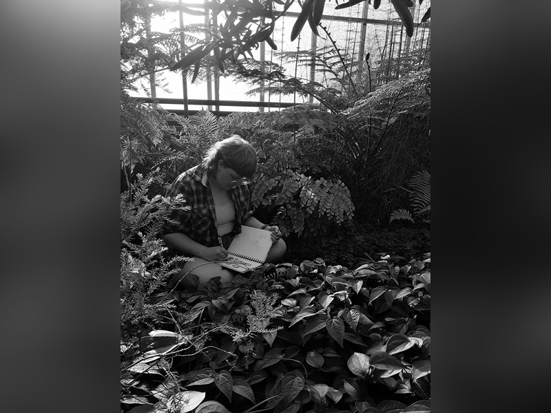 student surrounded by plants