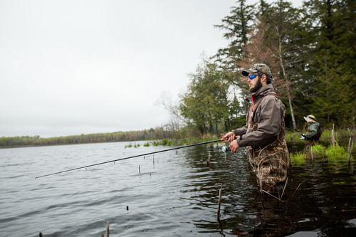 Man standing in water with a fishing rod