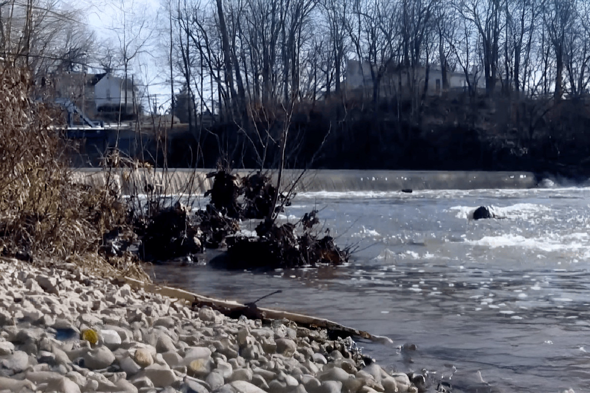 River dam with trees on side in winter.