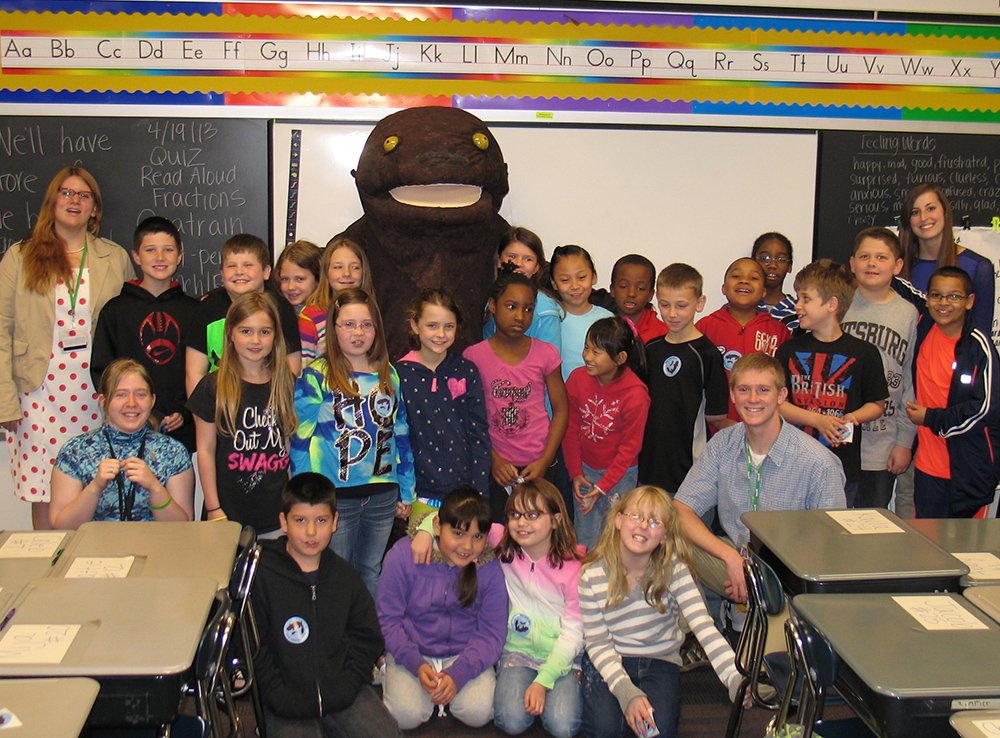 Herbie the Hellbender at school with classroom teacher and kids.
