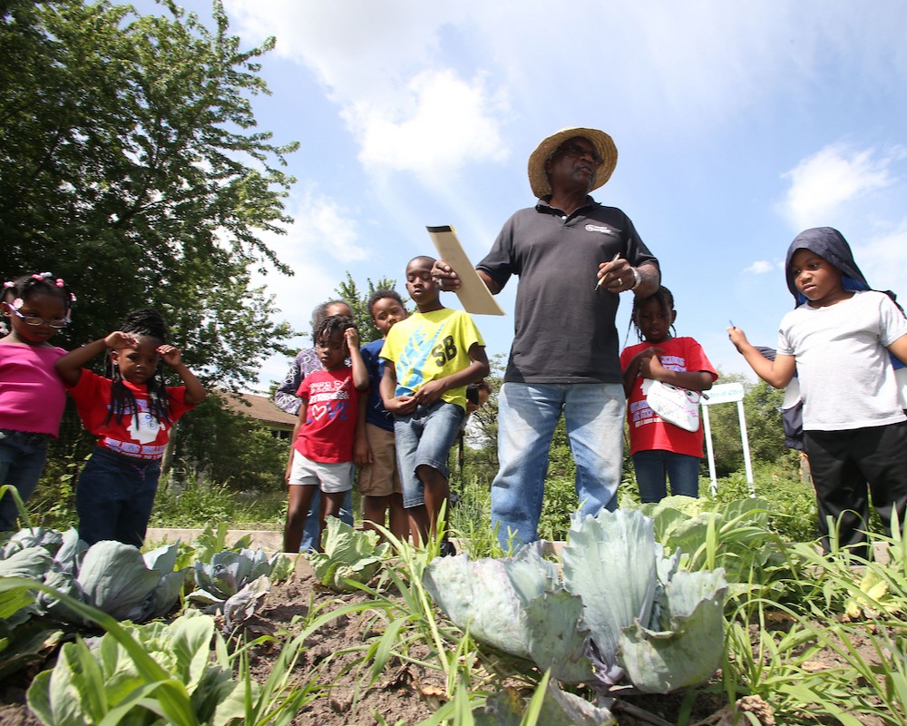 Teacher with students in garden.
