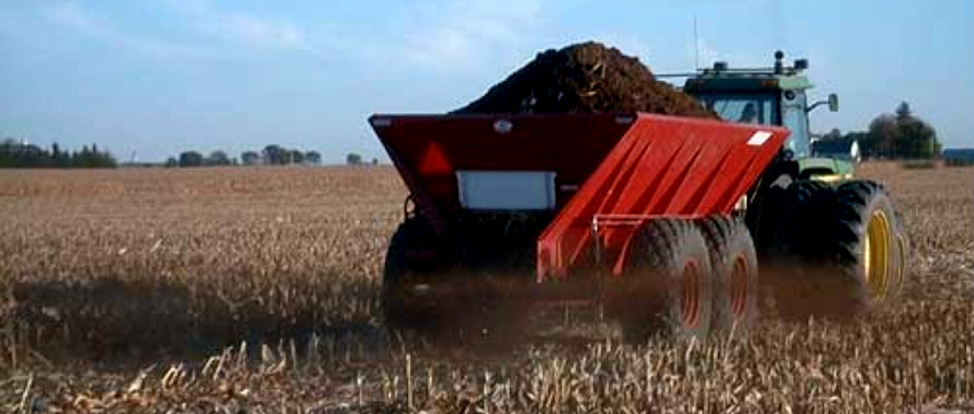 Tractor with trailer spreading field fertilizer